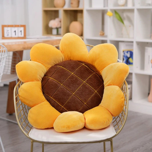 Soft sunflower throw pillow with plush yellow petals and brown quilted center on chair 