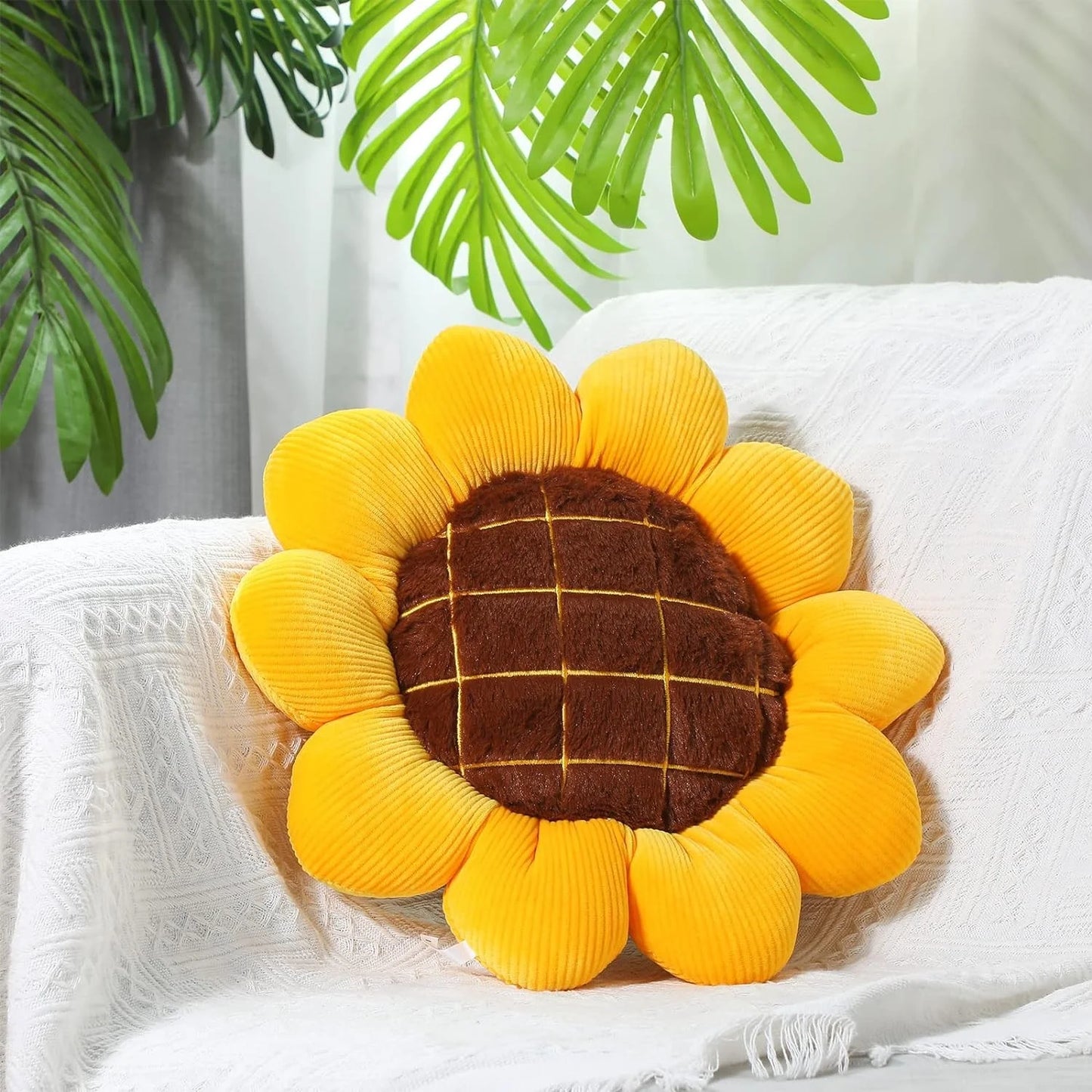 Soft sunflower throw pillow with plush yellow petals and brown quilted center on chair&nbsp;