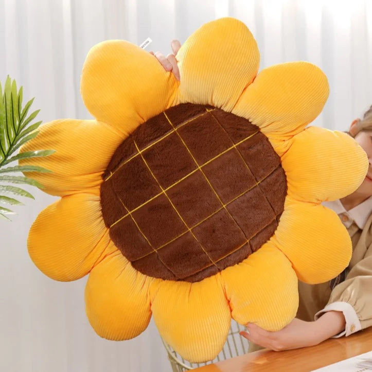 Soft sunflower throw pillow with plush yellow petals and brown quilted center on chair&nbsp;